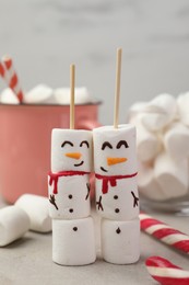 Photo of Funny snowmen made of marshmallows and other sweets on light table