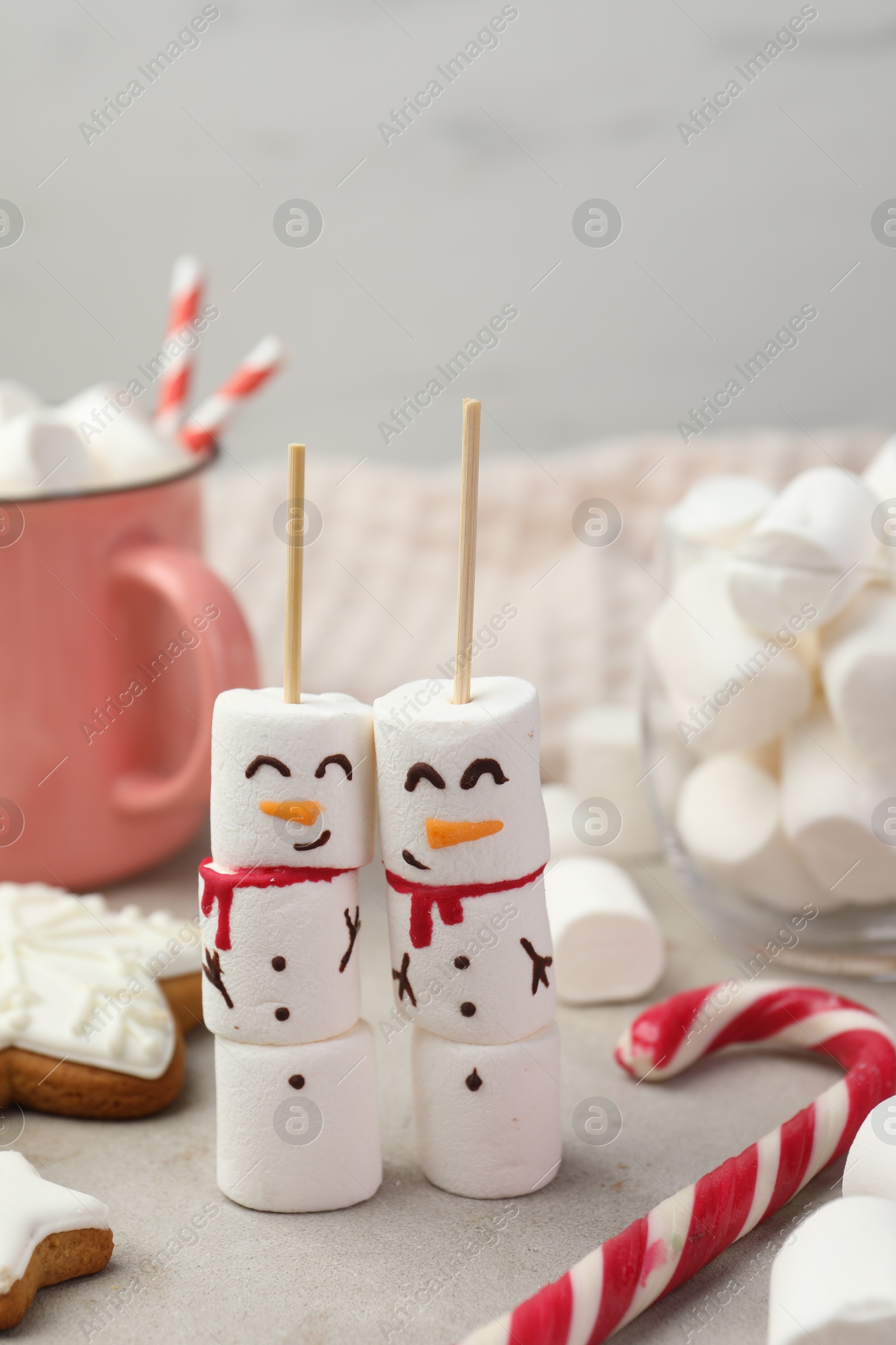 Photo of Funny snowmen made of marshmallows and other sweets on light table