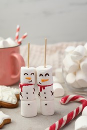 Photo of Funny snowmen made of marshmallows and other sweets on light table