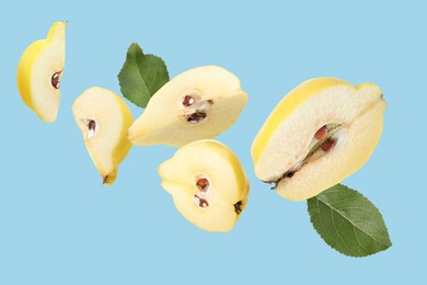 Image of Pieces of fresh quinces and green leaves flying on light blue background