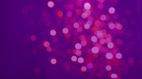 Image of Colorful blurred lights on purple backdrop, bokeh effect. Halloween background