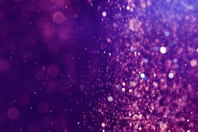 Pink glitter falling on blue purple gradient background, bokeh effect. Halloween backdrop