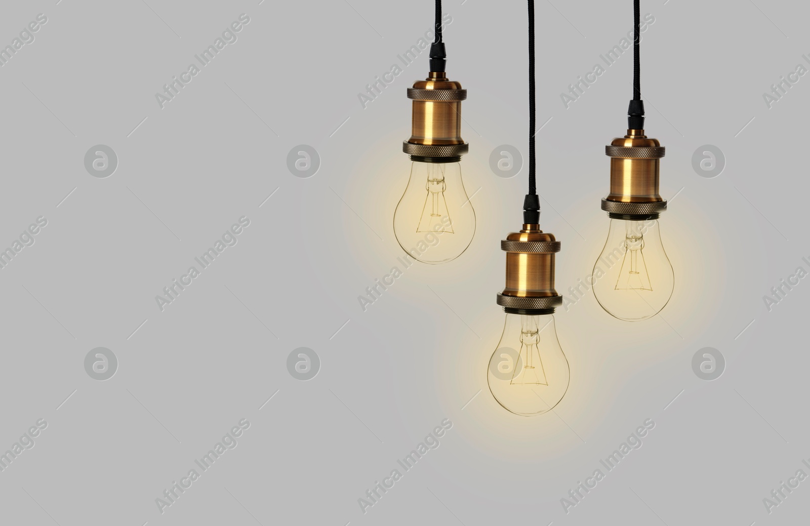 Image of Incandescent light bulbs on gray background, space for text