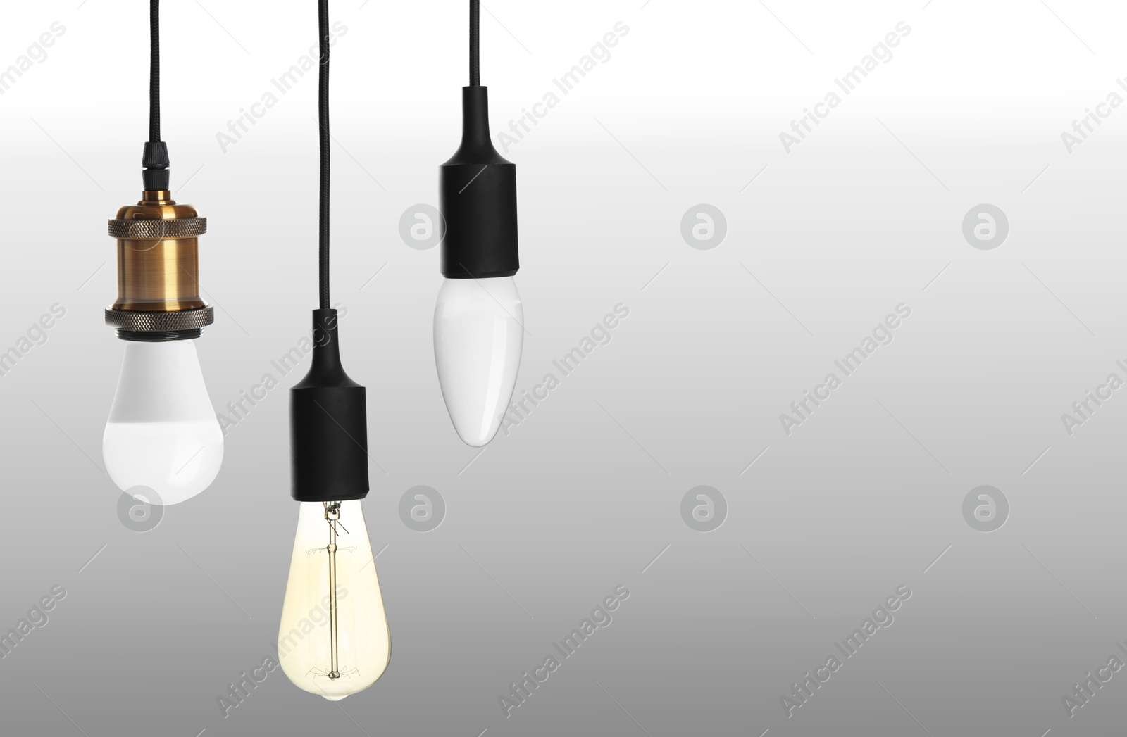 Image of Different incandescent light bulbs on gray background, space for text