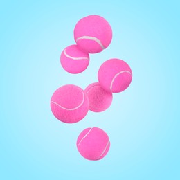 Image of Many pink tennis balls in air on light blue background