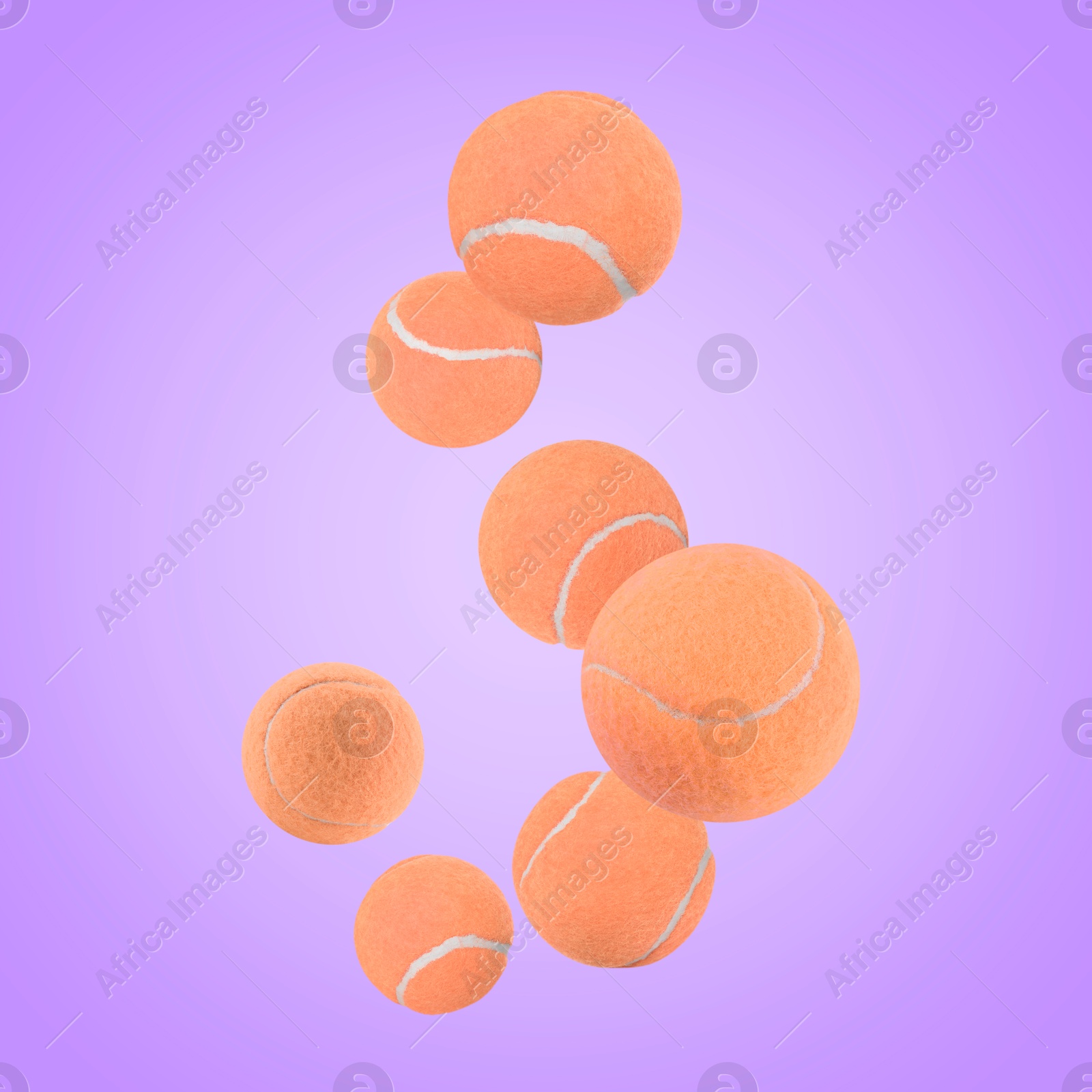 Image of Many orange tennis balls flying on violet background