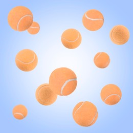 Image of Many pale orange tennis balls flying on light blue gradient background