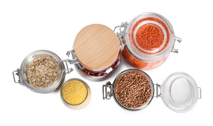 Different cereals and legumes in glass jars isolated on white, top view