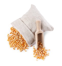 Photo of Fresh corn kernels, overturned burlap sack and wooden scoop isolated on white, top view