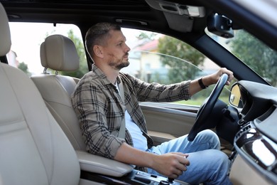 Photo of Man holding steering wheel while driving car