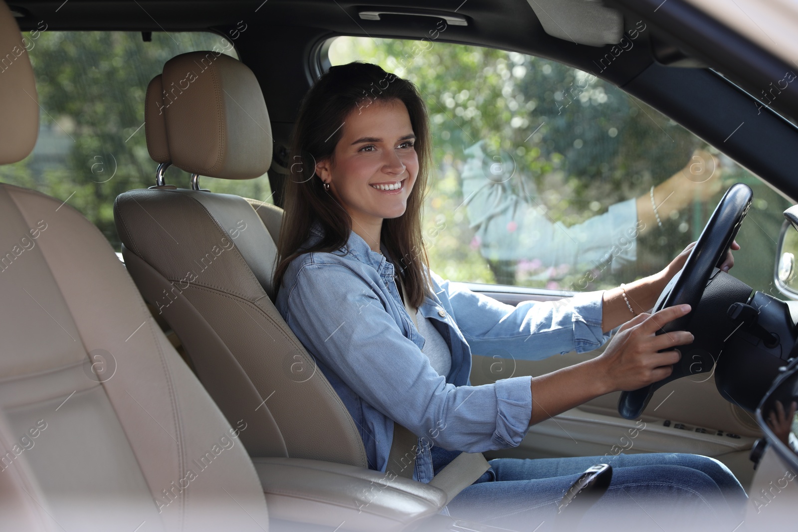 Photo of Smiling woman holding steering wheel while driving car