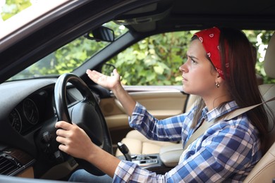 Photo of Emotional woman holding steering wheel while driving car, view from outside