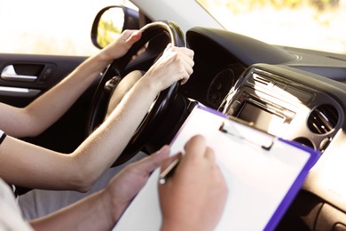 Driving school. Student passing driving test with examiner in car, closeup