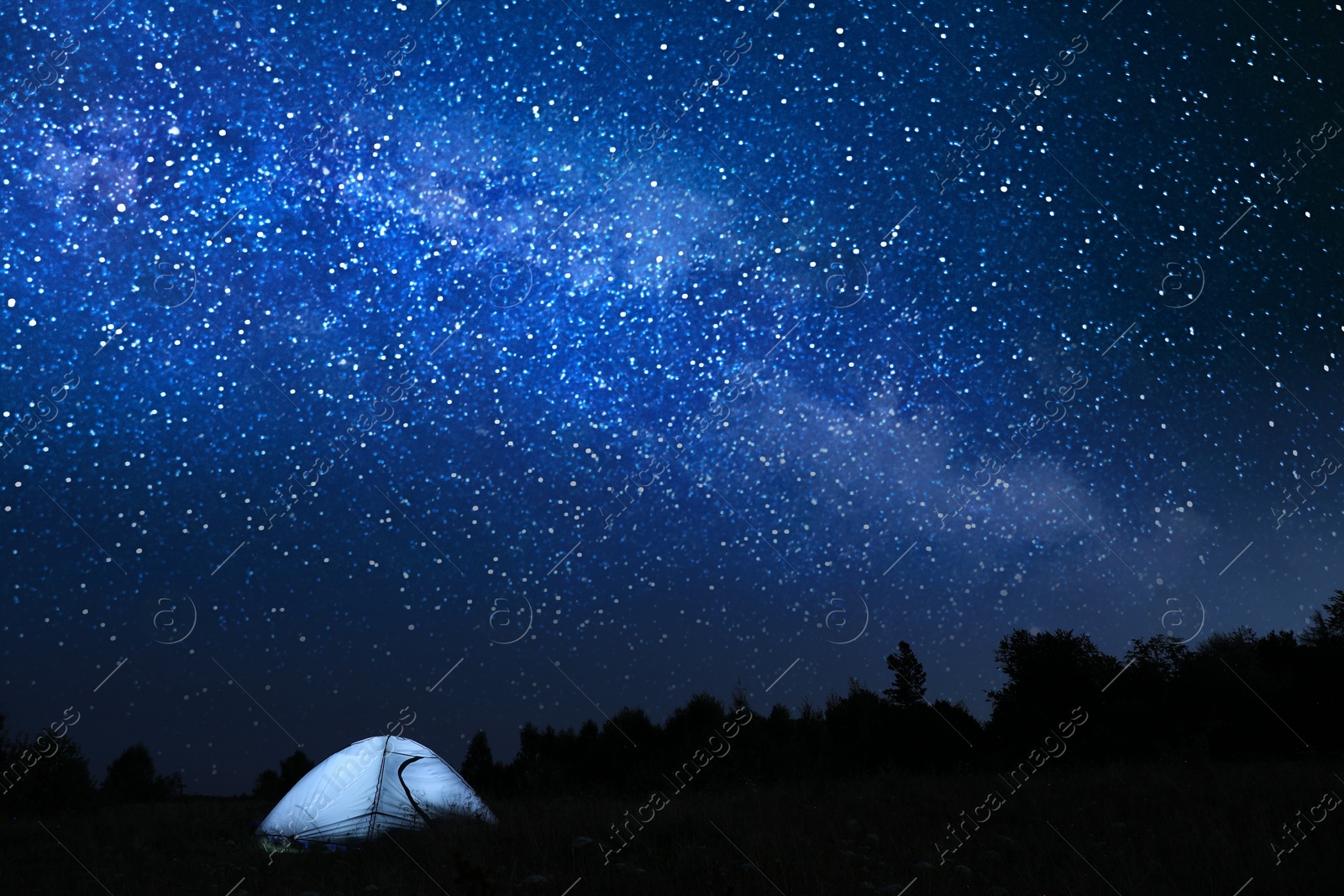 Photo of Modern camping tent in wilderness at night, slow shutter speed effect