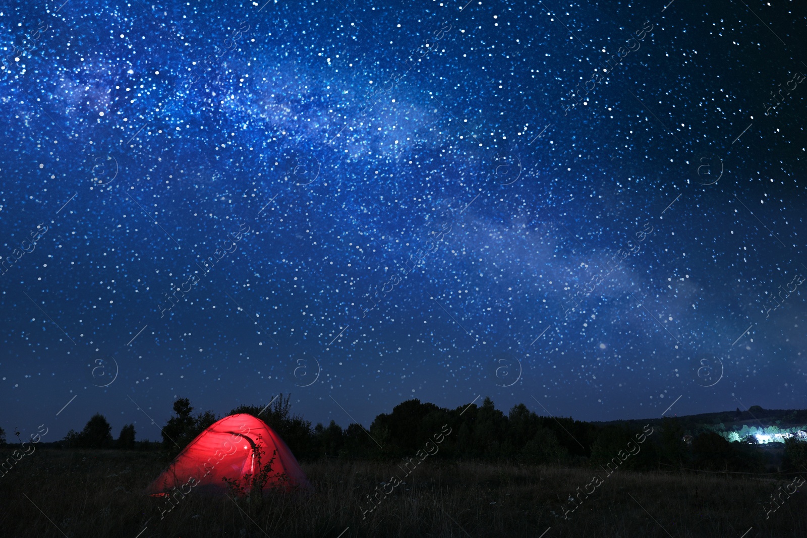 Photo of Modern camping tent in wilderness at night, slow shutter speed effect