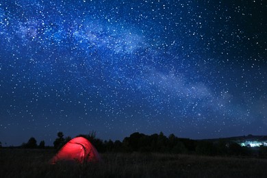 Photo of Modern camping tent in wilderness at night, slow shutter speed effect