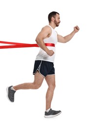 Photo of Handsome young man crossing red finish line on white background