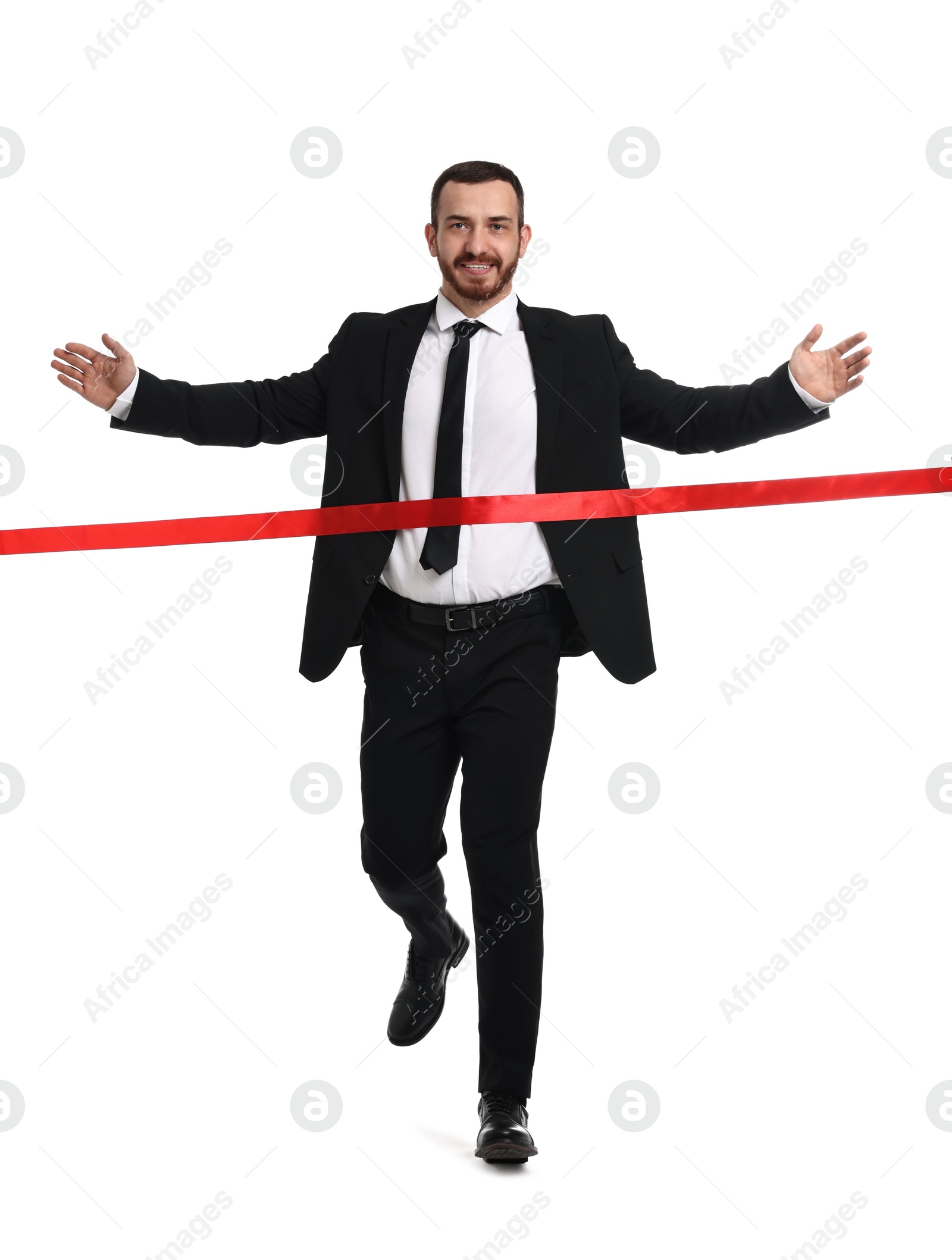 Photo of Young businessman in suit crossing red finish line on white background