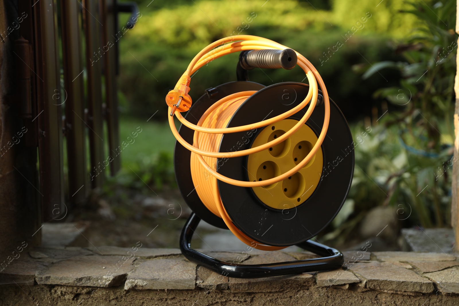 Photo of One extension cord reel outdoors. Electrician's equipment