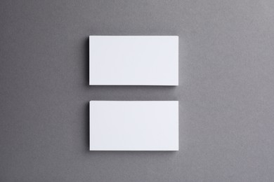 Blank business cards on grey background, top view. Mockup for design