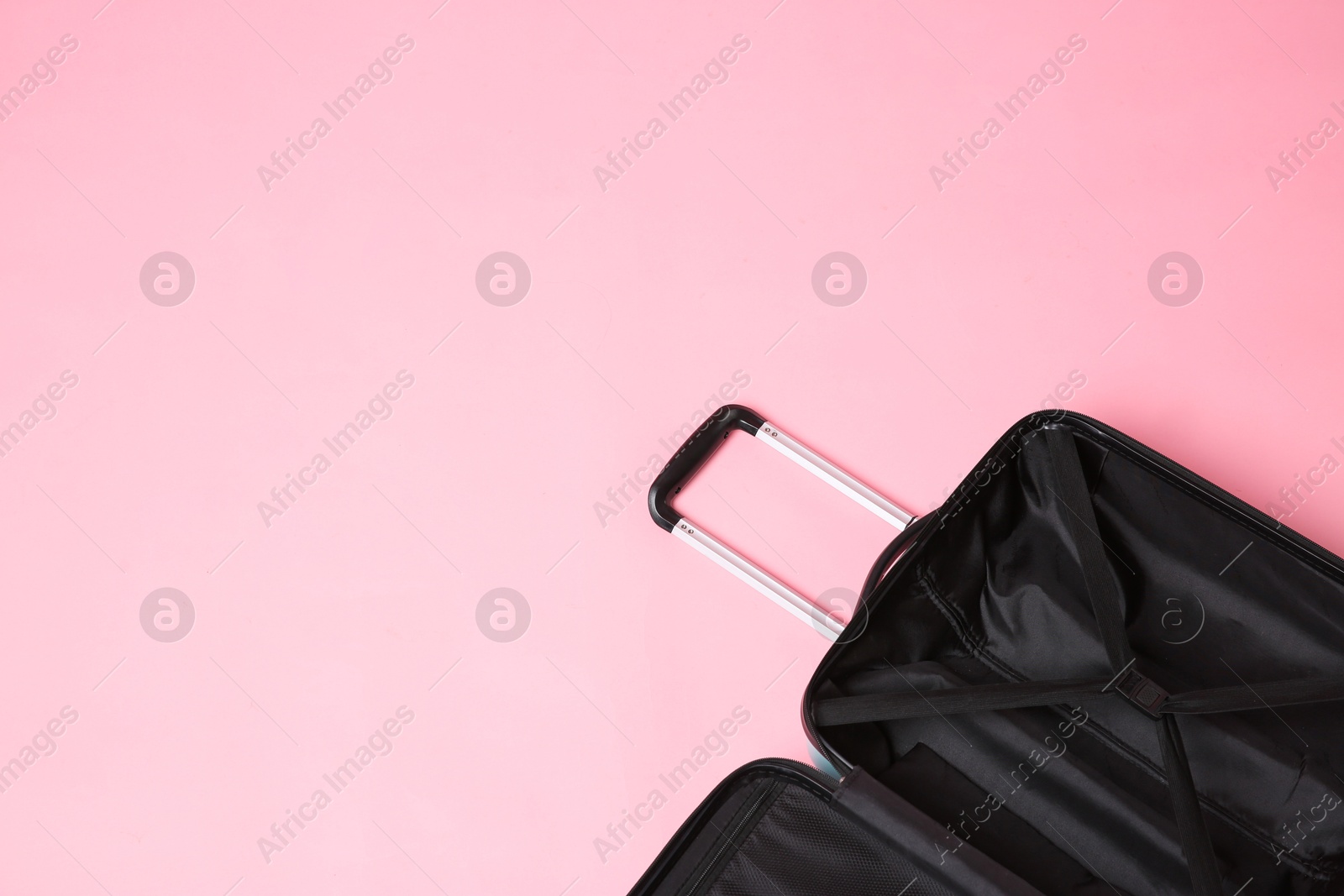 Photo of Open empty suitcase on pink background, above view. Space for text