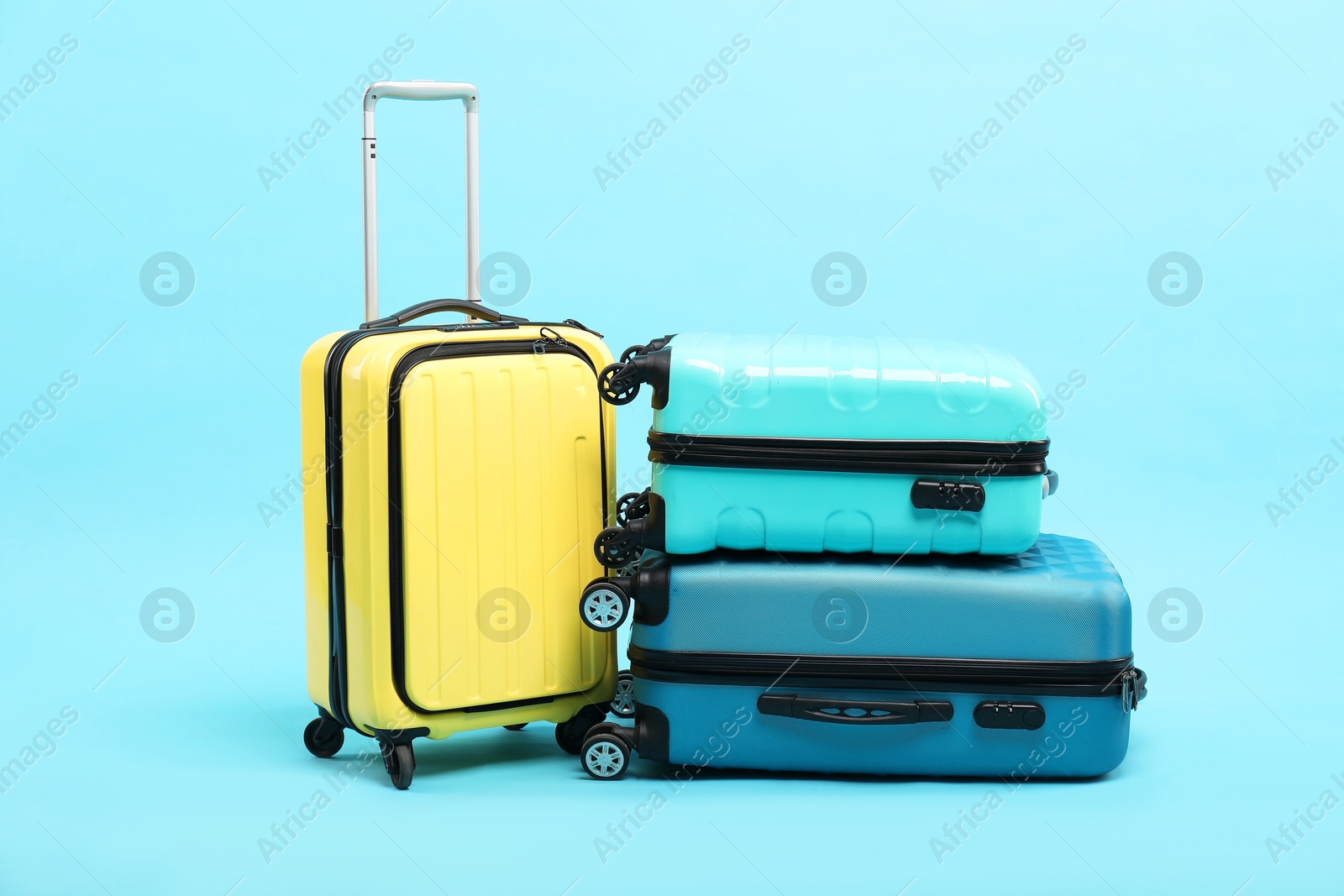 Photo of Different bright suitcases on light blue background