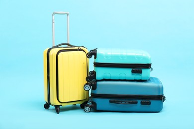 Photo of Different bright suitcases on light blue background