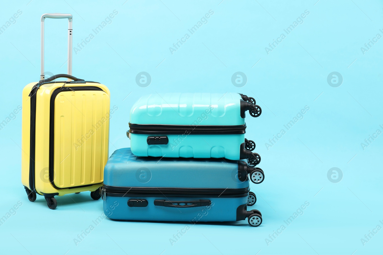 Photo of Different bright suitcases on light blue background