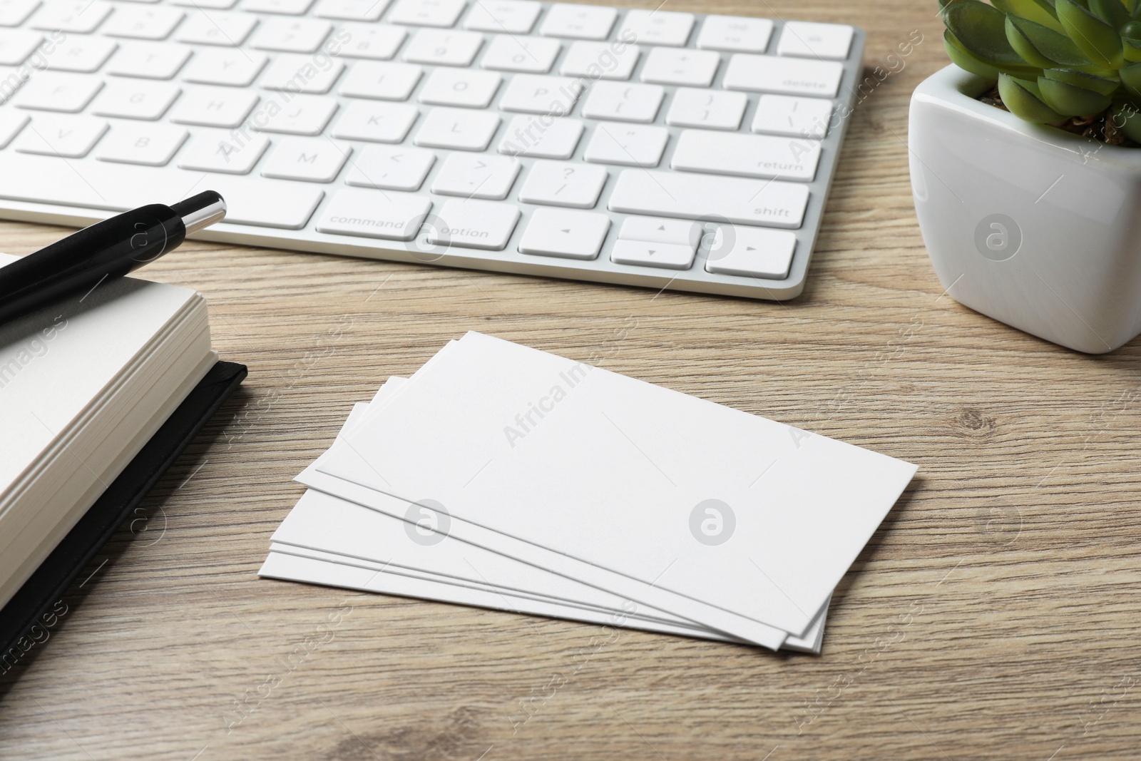 Photo of Blank business cards, stationery and keyboard on wooden table. Mockup for design