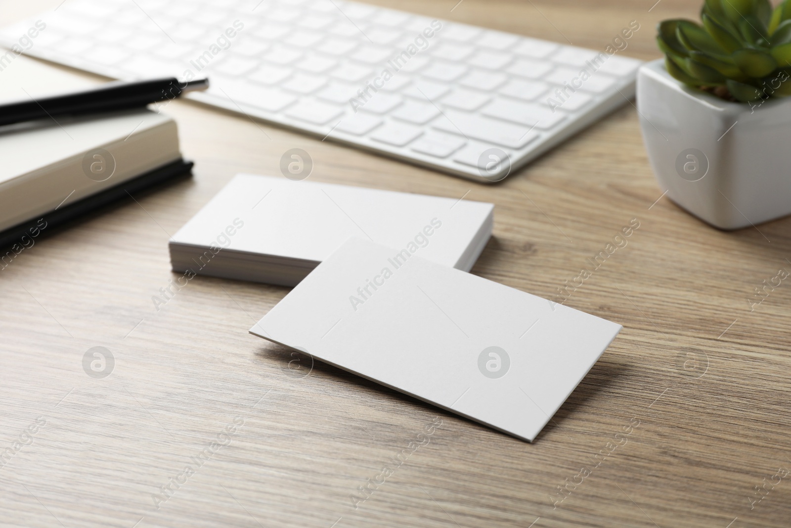 Photo of Blank business cards and keyboard on wooden table. Mockup for design