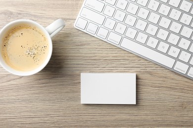 Photo of Blank business cards, coffee and keyboard on wooden table, flat lay. Mockup for design