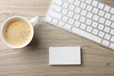 Photo of Blank business cards, coffee and keyboard on wooden table, flat lay. Mockup for design