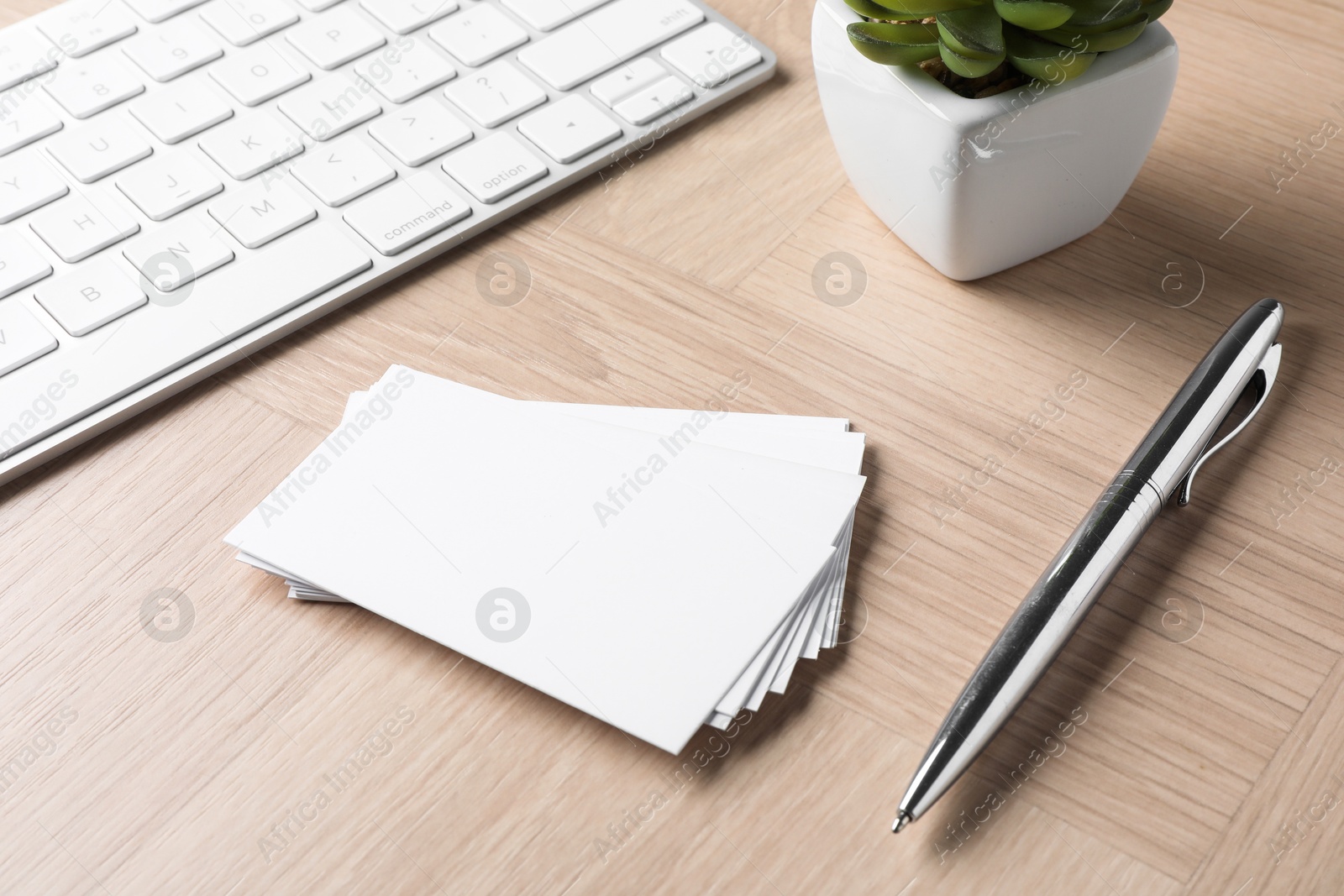 Photo of Blank business cards, pen and keyboard on wooden table. Mockup for design