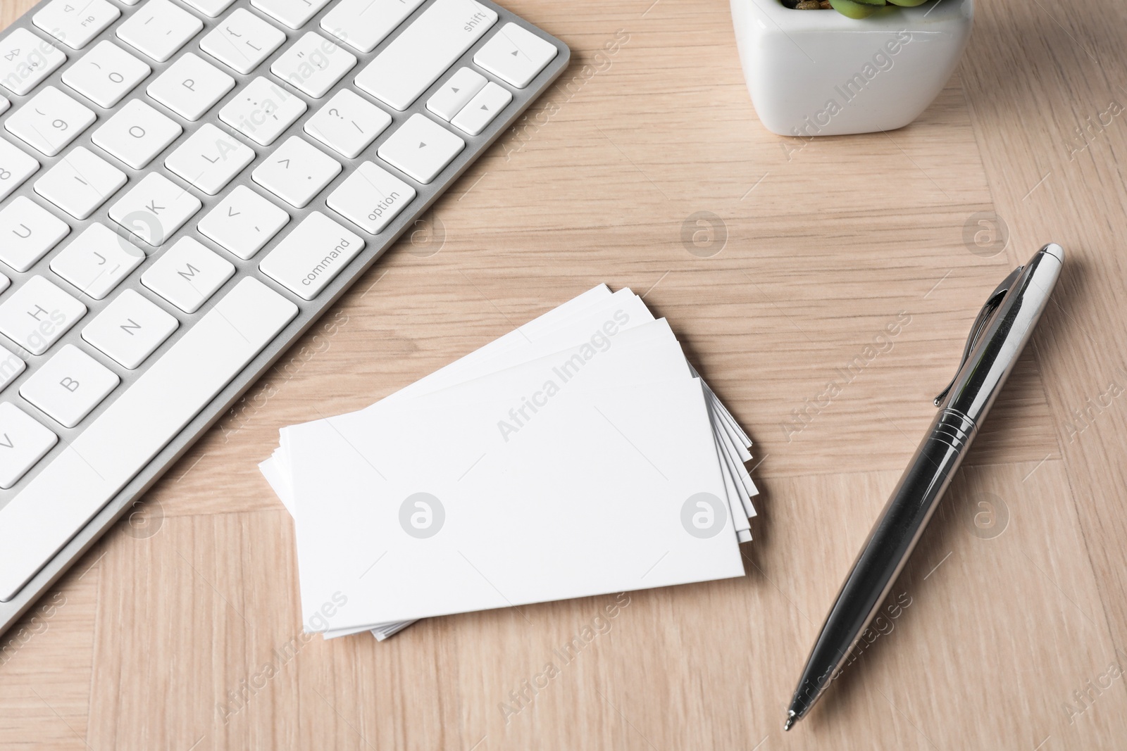 Photo of Blank business cards, pen and keyboard on wooden table. Mockup for design