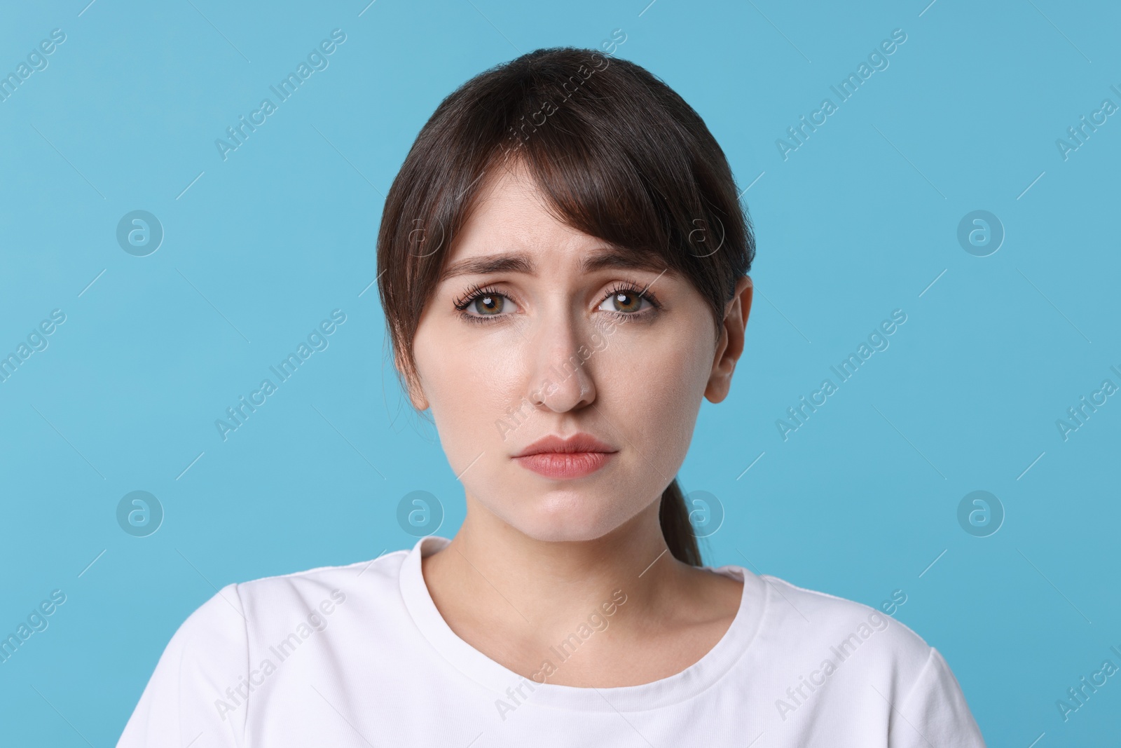 Photo of Portrait of frustrated woman on light blue background