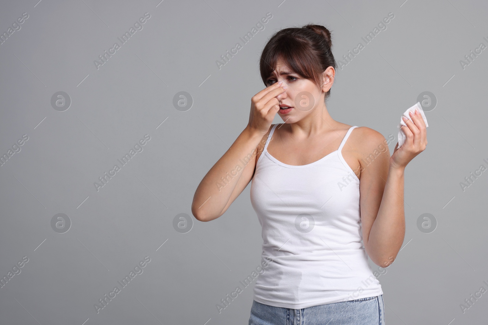 Photo of Woman with napkin suffering from sinusitis on grey background. Space for text