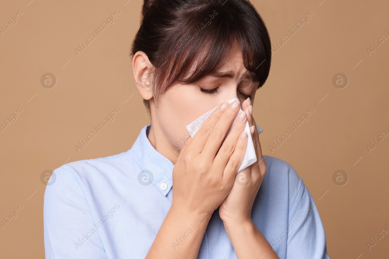 Photo of Woman with napkin suffering from sinusitis on beige background