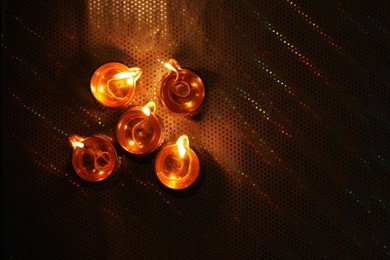 Diwali celebration. Diya lamps on color background, flat lay. Space for text