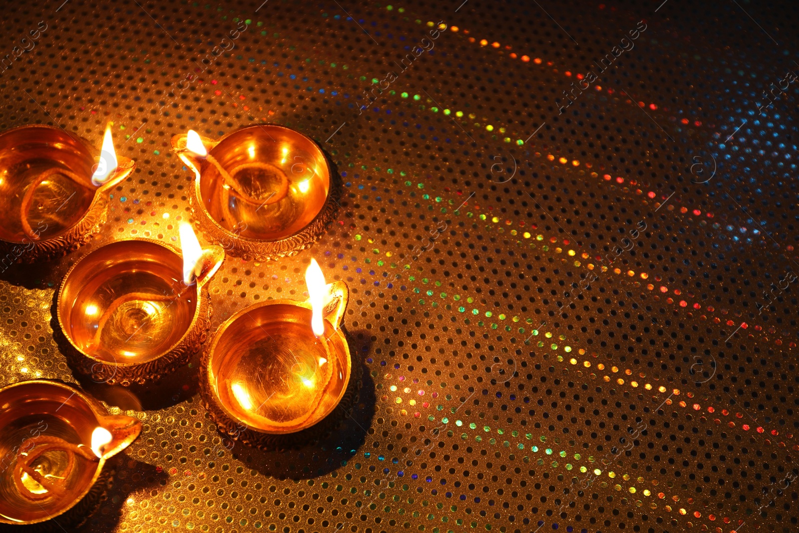 Photo of Diwali celebration. Diya lamps on color background. Space for text