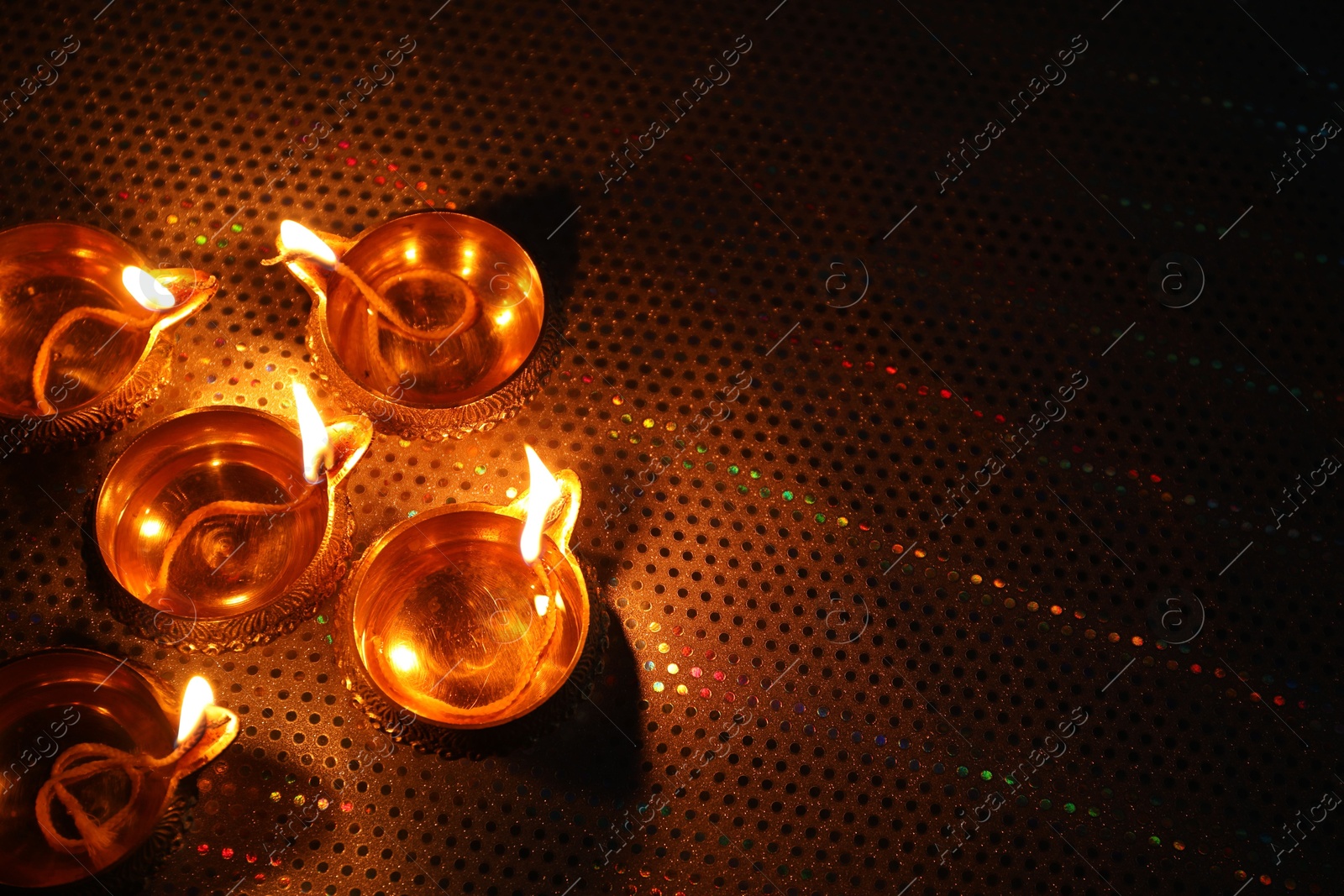 Photo of Diwali celebration. Diya lamps on color background. Space for text