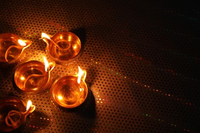 Diwali celebration. Diya lamps on color background. Space for text