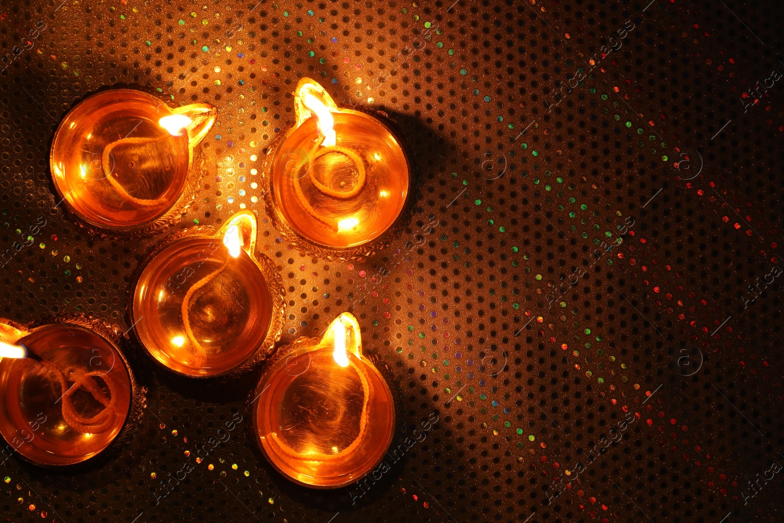 Photo of Diwali celebration. Diya lamps on color background, flat lay. Space for text