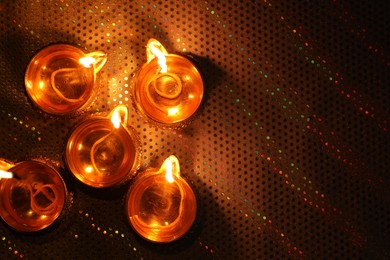 Diwali celebration. Diya lamps on color background, flat lay. Space for text