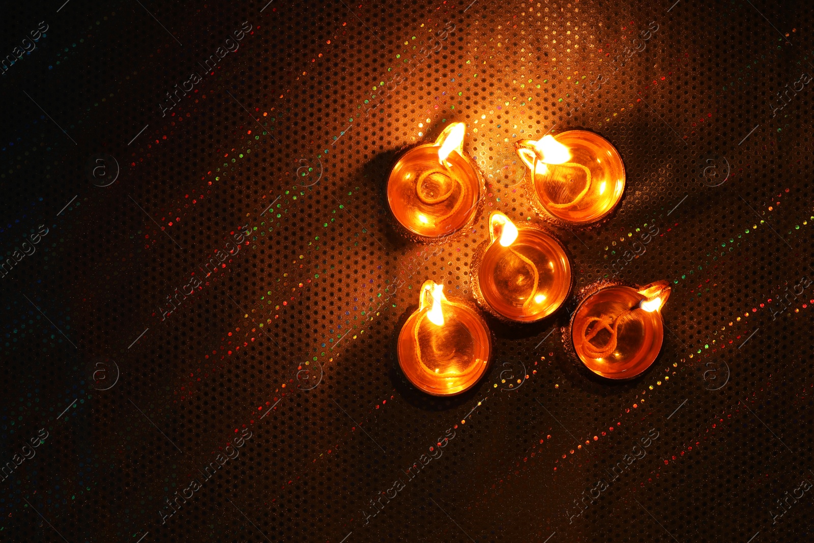 Photo of Diwali celebration. Diya lamps on color background, flat lay. Space for text