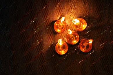 Photo of Diwali celebration. Diya lamps on color background, flat lay. Space for text