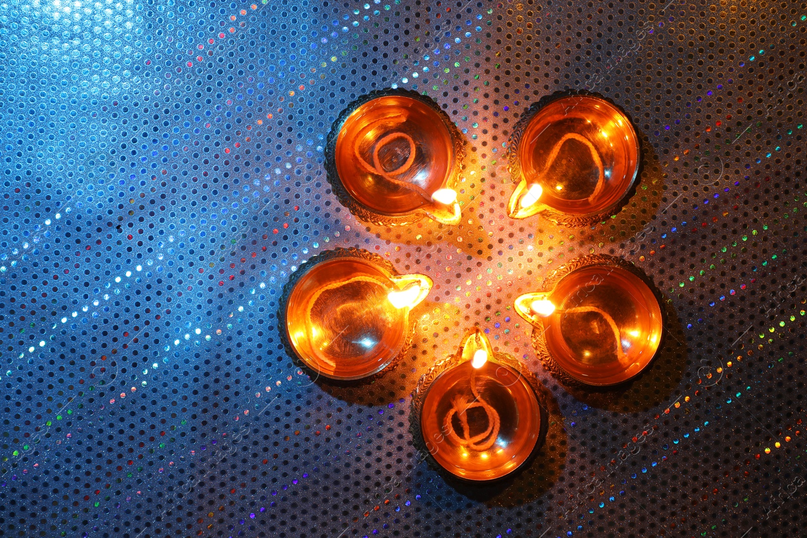 Photo of Diwali celebration. Diya lamps on color background, flat lay. Space for text