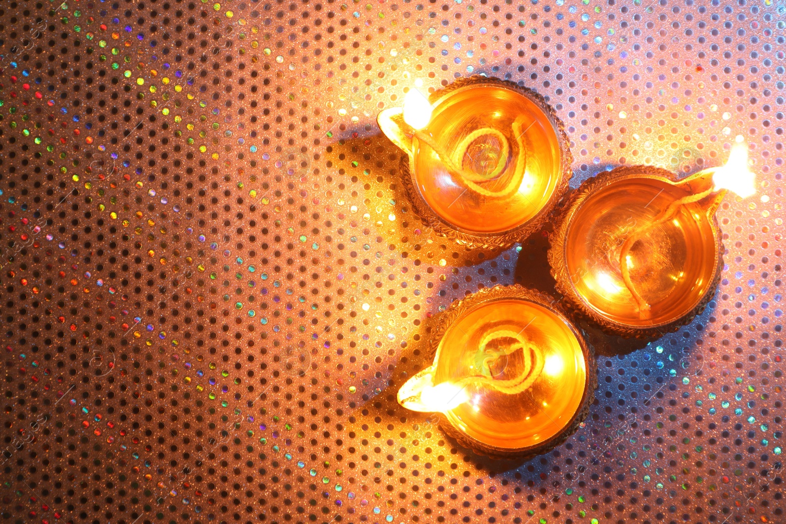 Photo of Diwali celebration. Diya lamps on color background, flat lay. Space for text