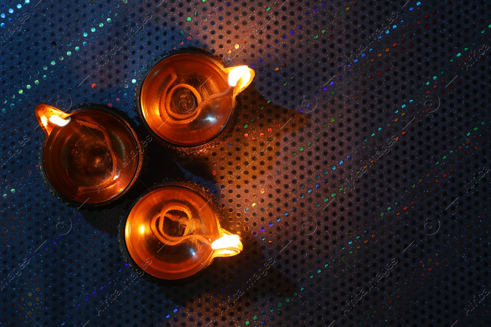 Photo of Diwali celebration. Diya lamps on color background, flat lay. Space for text