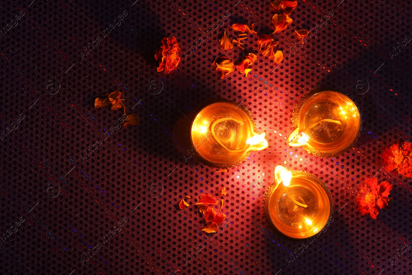 Photo of Diwali celebration. Diya lamps and beautiful flowers on dark background, top view