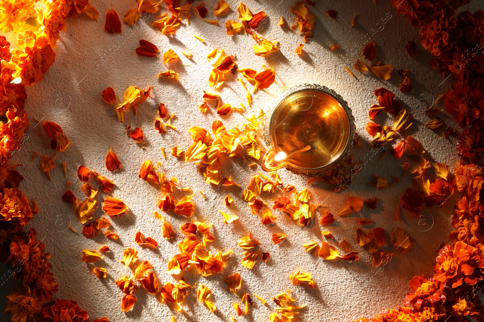 Photo of Diwali celebration. Diya lamp and beautiful flowers on light background, top view